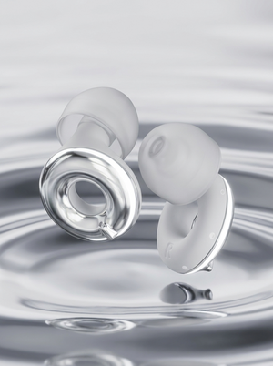 Pair of Silensea earplugs in Moonlight Silver above rippling water