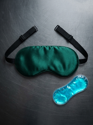 Silensea cooling sleep mask in Forest Green laid flat beside its reusable gel pack