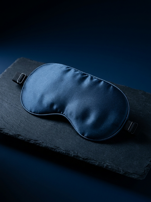 Silensea cooling sleep mask in Midnight Navy on a dark slate board
